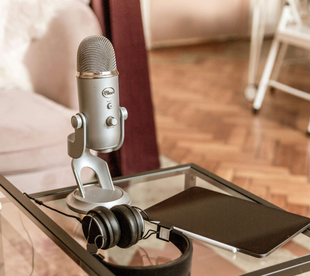 Podcast microphone, headset and tablet on table